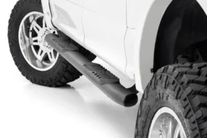 Oval nerf steps mounted under a pickup truck crew cab