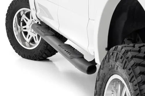 Oval nerf steps mounted under a pickup truck crew cab